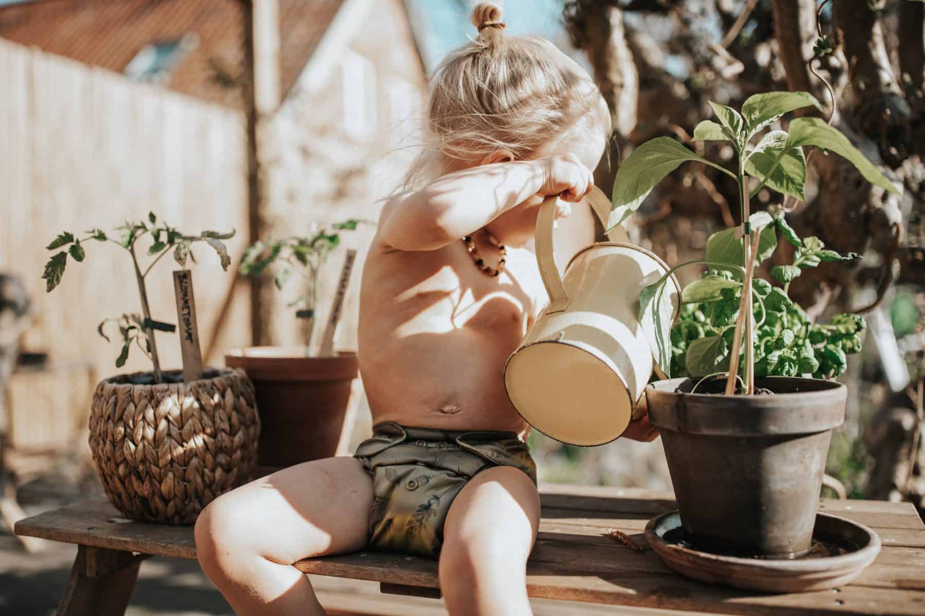dreng med stofble vander planter