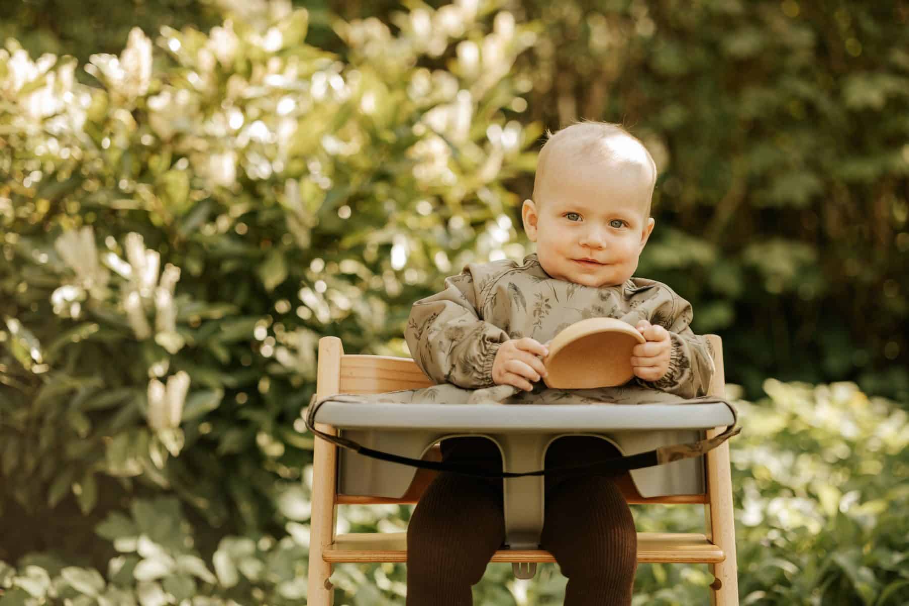 Baby ved bord med langærmet hagesmæk på